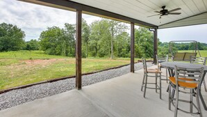An outdoor patio with a table and chairs, a ceiling fan, and a view of a grassy field and trees. - Burkesville Cabin, 3 Mi to Dale Hollow Lake! (Burkesville)