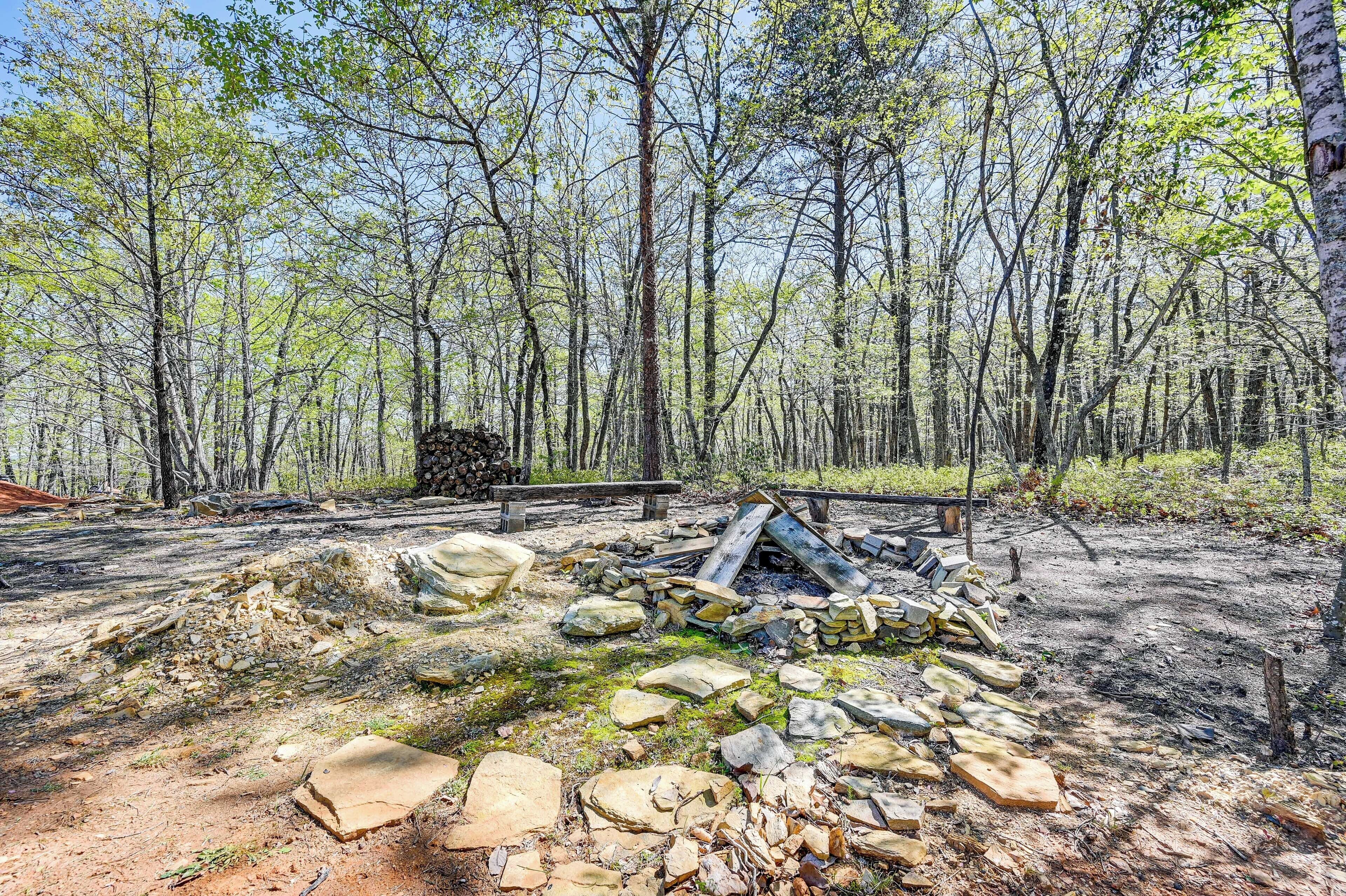 Een open plek in het bos met een stapel rotsen en een houten constructie.