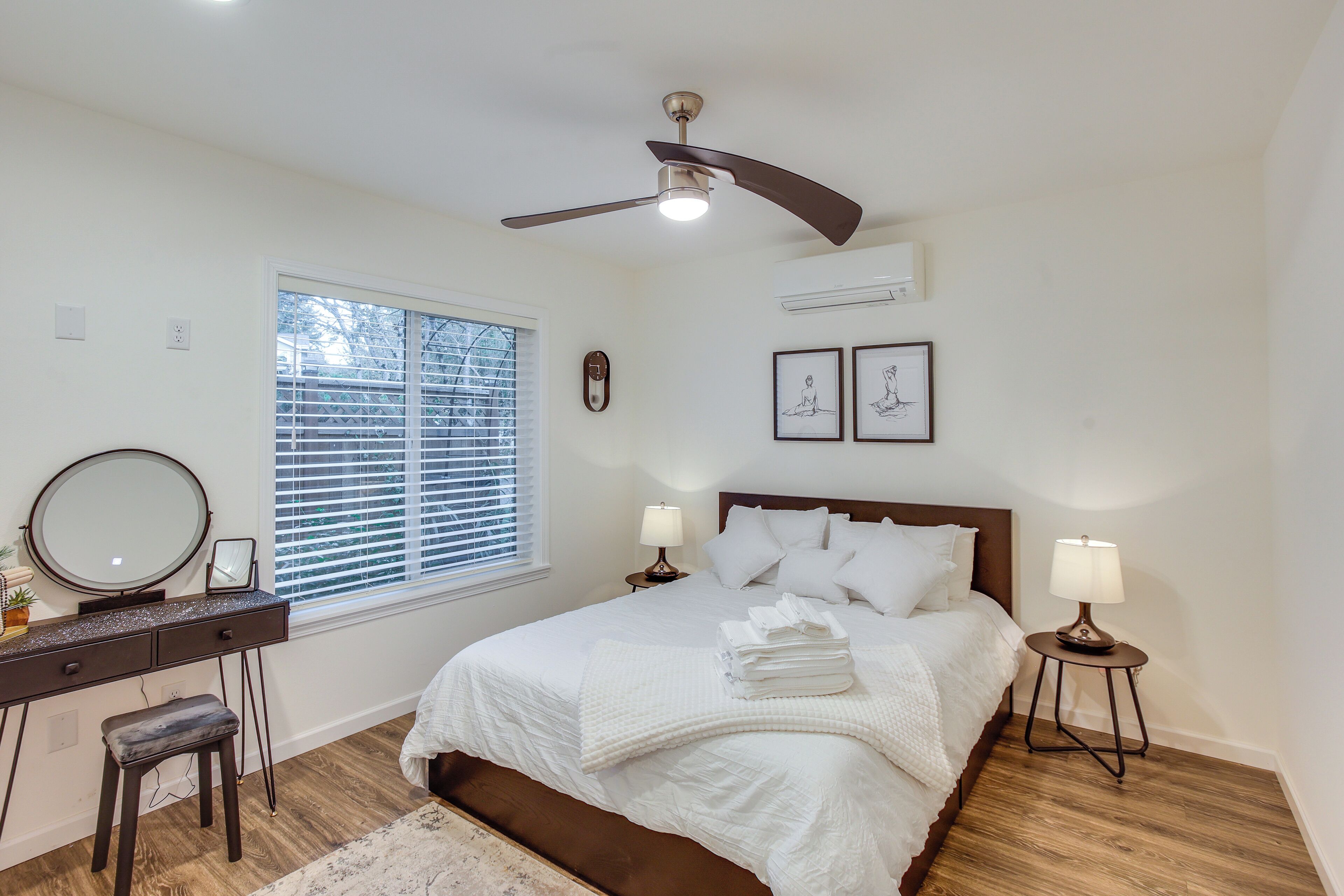 Une chambre à coucher avec un lit, des tables de chevet, un bureau et une chaise.