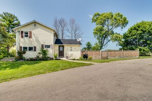 A two-story house with a front yard, a driveway, and a wooden fence. - Walworth Home w/ Hot Tub - Near Golf Courses! (Walworth)