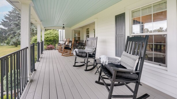 A covered porch with rocking chairs and a lantern.