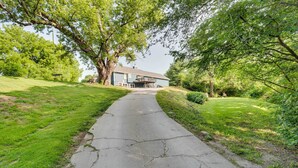 A pathway leading to a house surrounded by lush greenery. - Missouri Studio Getaway: Close to Parks & Hiking (Liberty)