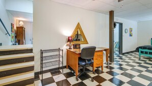 A room with a checkered floor, a desk with a chair, a bed, a ceiling fan, and a wall-mounted lamp. - Killen Vacation Rental: Walk to Wilson Lake! (Killen)