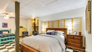 A bedroom with a checkered floor, a wooden bed, a nightstand, and a traditional Japanese shoji screen. - Killen Vacation Rental: Walk to Wilson Lake! (Killen)