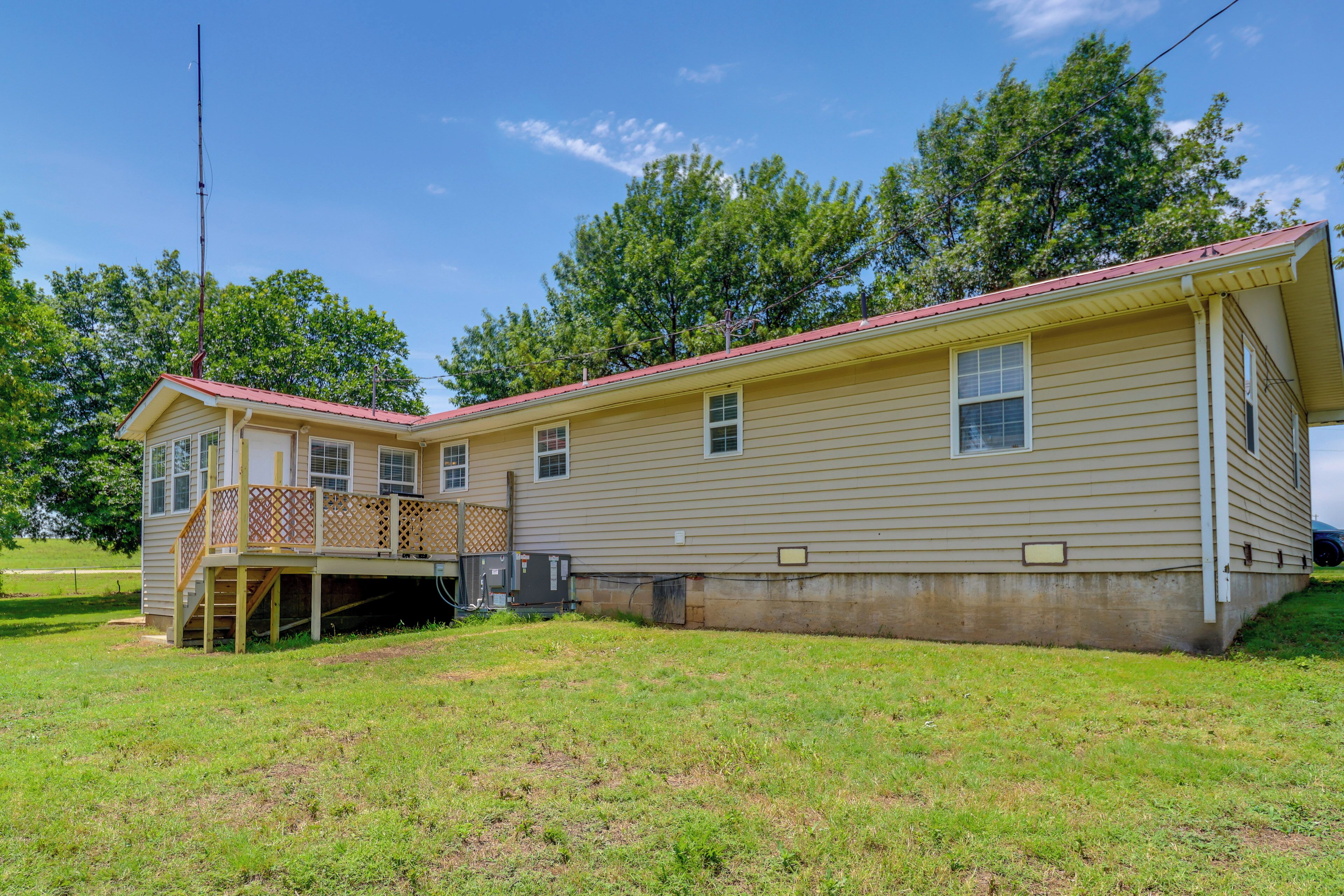 A two-story house with a covered porch and a small deck.