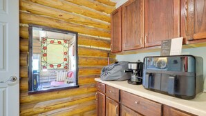 Une cuisine aux murs en bois, avec une machine à café et une fenêtre ornée de vitraux.