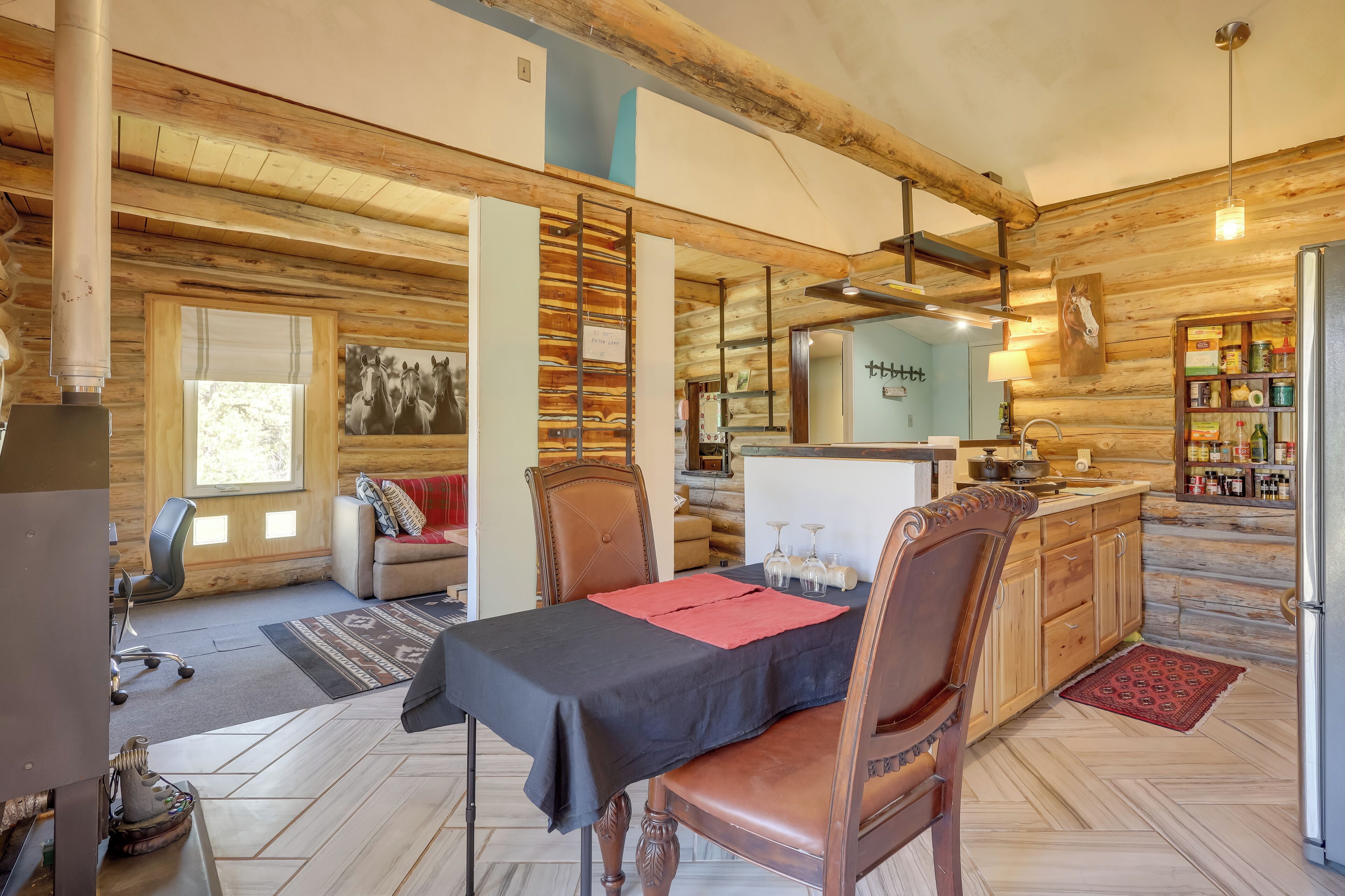 A rustic wooden interior with a dining area, kitchen, and living space.