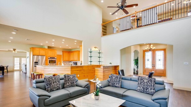 A spacious living area with a gray sofa set, a marble coffee table, and a kitchen in the background. - The Oasis Ranch 20-acre Ranch in Whitewright! (Whitewright)