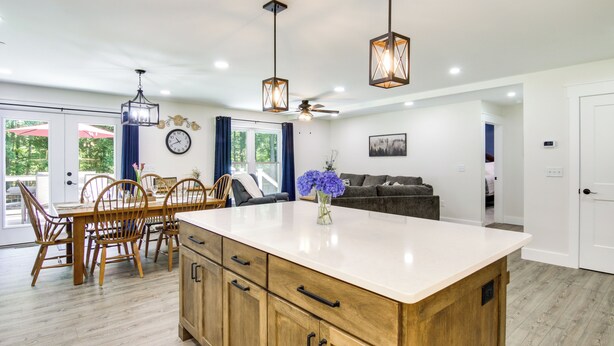 A modern kitchen with a central island, wooden cabinets, and pendant lighting. - Hot Tub Haven 2 Mi to Beach! Christy's Cottage (Snow Hill)