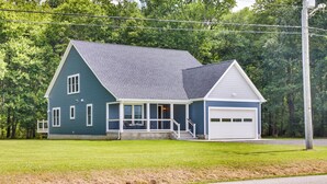 A two-story house with a covered porch, a garage, and a well-maintained lawn. - Hot Tub Haven 2 Mi to Beach! Christy's Cottage (Snow Hill)