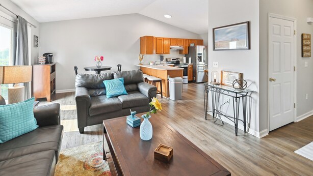 Un salon moderne comprenant un canapé, une table basse et un coin repas avec une petite table et des chaises.