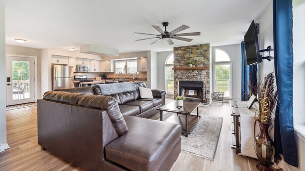 A spacious living room with a sectional sofa, a fireplace, and a kitchen in the background. - 'heaven on the Hill' Retreat w/ Deck + Gas Grill! (Frewsburg)