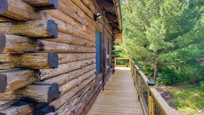 Une cabane en bois dotée d’une terrasse en bois qui mène à une porte bleue.