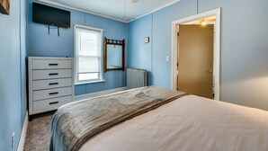 A bedroom with a bed, a dresser, a mirror, a ceiling fan, and a door. - Bath Vacation Rental Condo w/ Pool Access! (Bath)