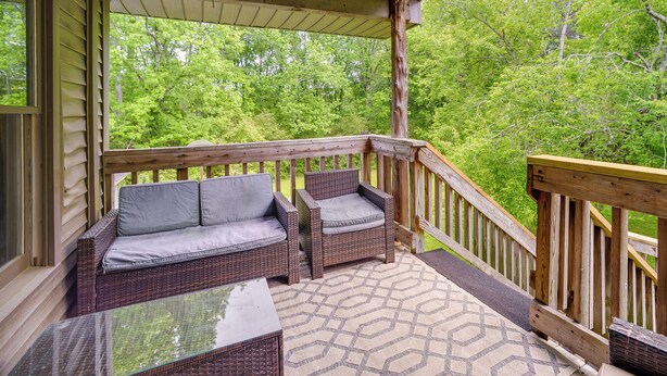 A covered porch with wicker furniture and a patterned floor. - 6 Mi to Scottsboro: Pet-friendly Cabin Apt (Hollywood)