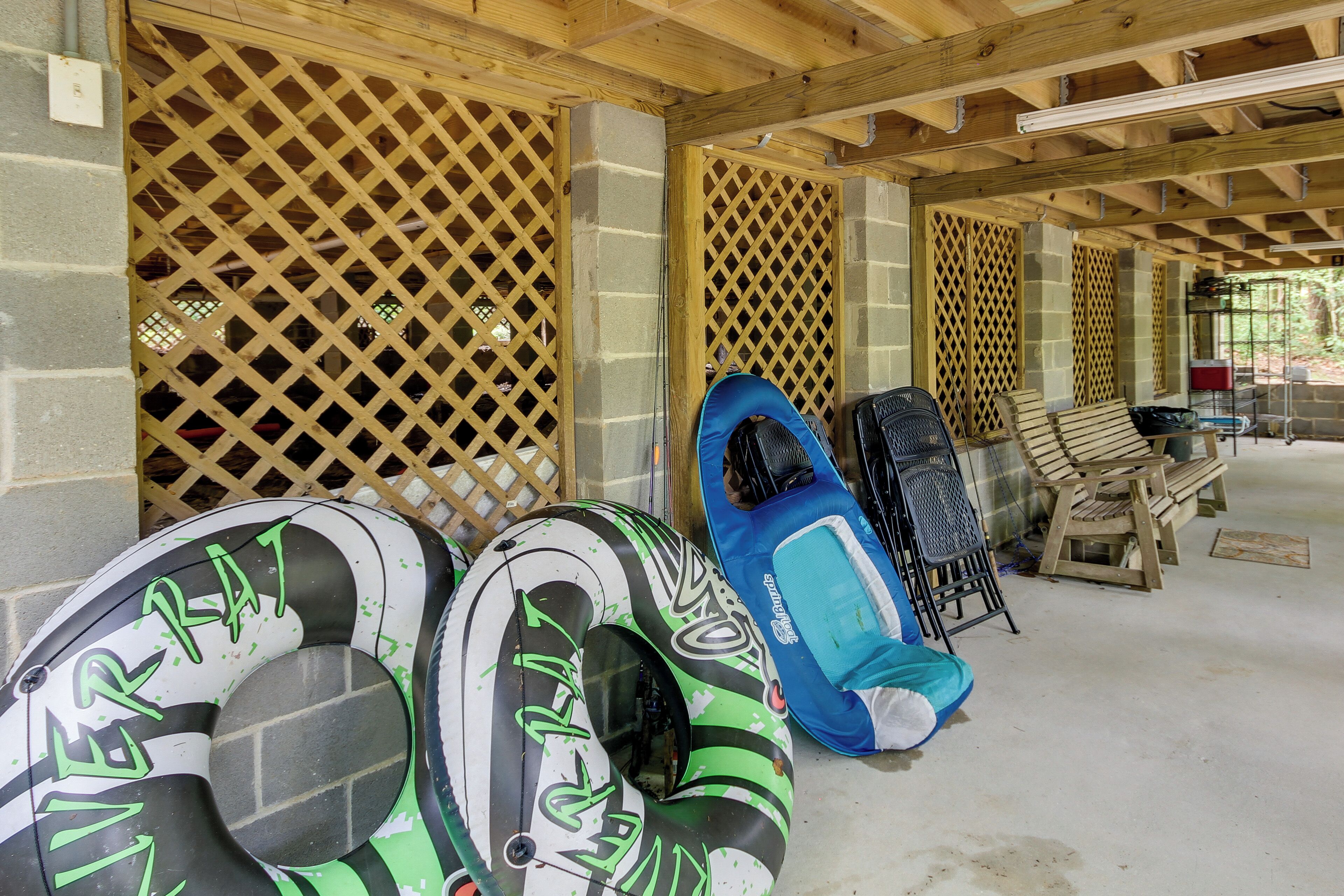 A covered outdoor area with wooden benches and inflatable rafts.