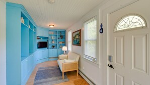 Um quarto com um armário azul, uma porta branca com vitral e uma parede branca com um quadro emoldurado.