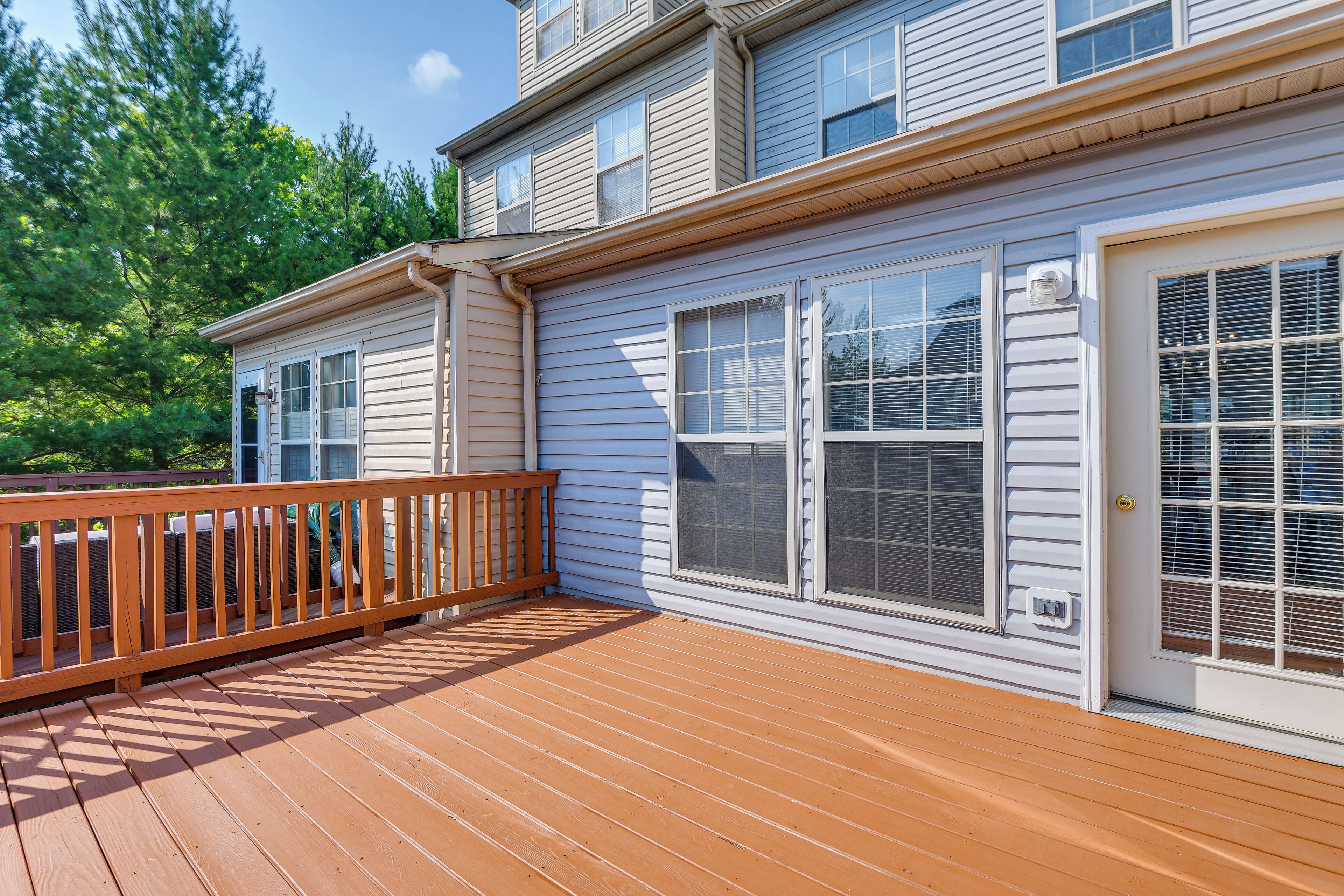 A two-story house with a wooden deck and large windows.