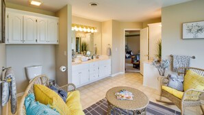 A well-lit bathroom with a vanity, toilet, and a mirror. - Sibley Home w/ Game Room & Expansive Yard! (Sibley)
