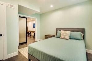 A bedroom with a bed, nightstand, and a door leading to another room. - Modern Lake Ontario Escape w/ Beach Access! (Henderson)