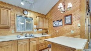 Ein Holzinterieur mit Küchenzeile, Barhocker und einer Kandelaber.