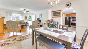 A dining area with a wooden table, floral placemats, and a chandelier. - Peaceful Chatham Home w/ Grill & Deck (Chatham)