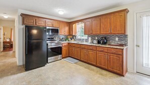A kitchen with wooden cabinets, stainless steel appliances, and a tiled backsplash. - Peaceful Chatham Home w/ Grill & Deck (Chatham)