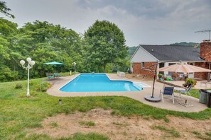 A backyard with a swimming pool, patio furniture, and a brick house. - Pet-friendly Union Vacation Rental With Pool! (Burlington)