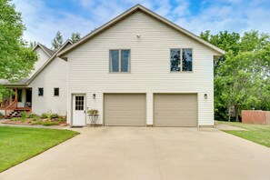 A two-story house with a front garage, a small porch, and a well-maintained lawn.