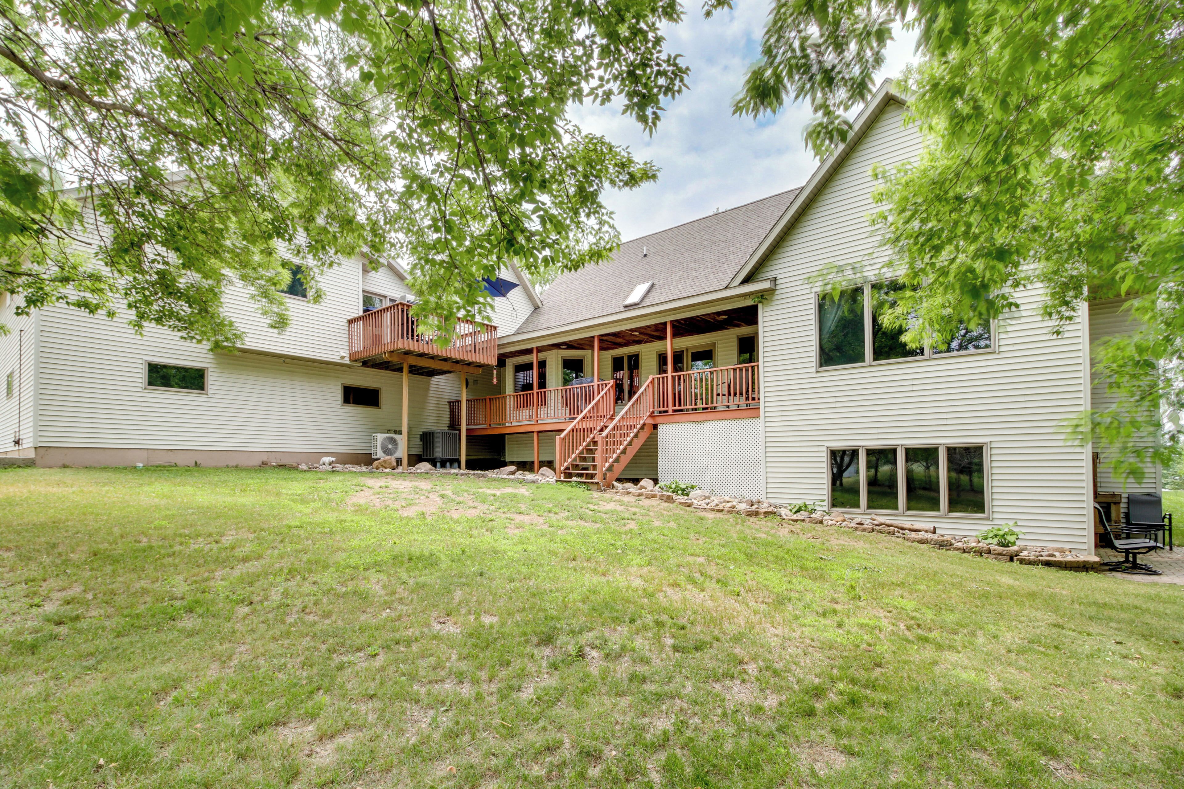 A two-story house with a covered porch and a small outdoor seating area.