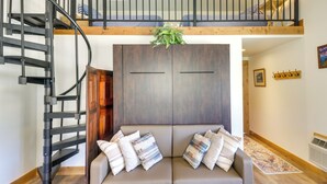 A modern interior with a spiral staircase, a sofa with patterned cushions, and a wooden ceiling. - Pet-friendly Elmo Home w/ Mountain & Lake Views! (Elmo)