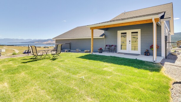 A house with a covered patio, a lawn, and a view of the mountains. - Pet-friendly Elmo Home w/ Mountain & Lake Views! (Elmo)