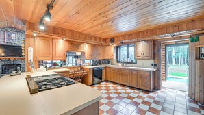 Une cuisine spacieuse avec des meubles en bois, un grand îlot central et un carrelage à motifs carrés.