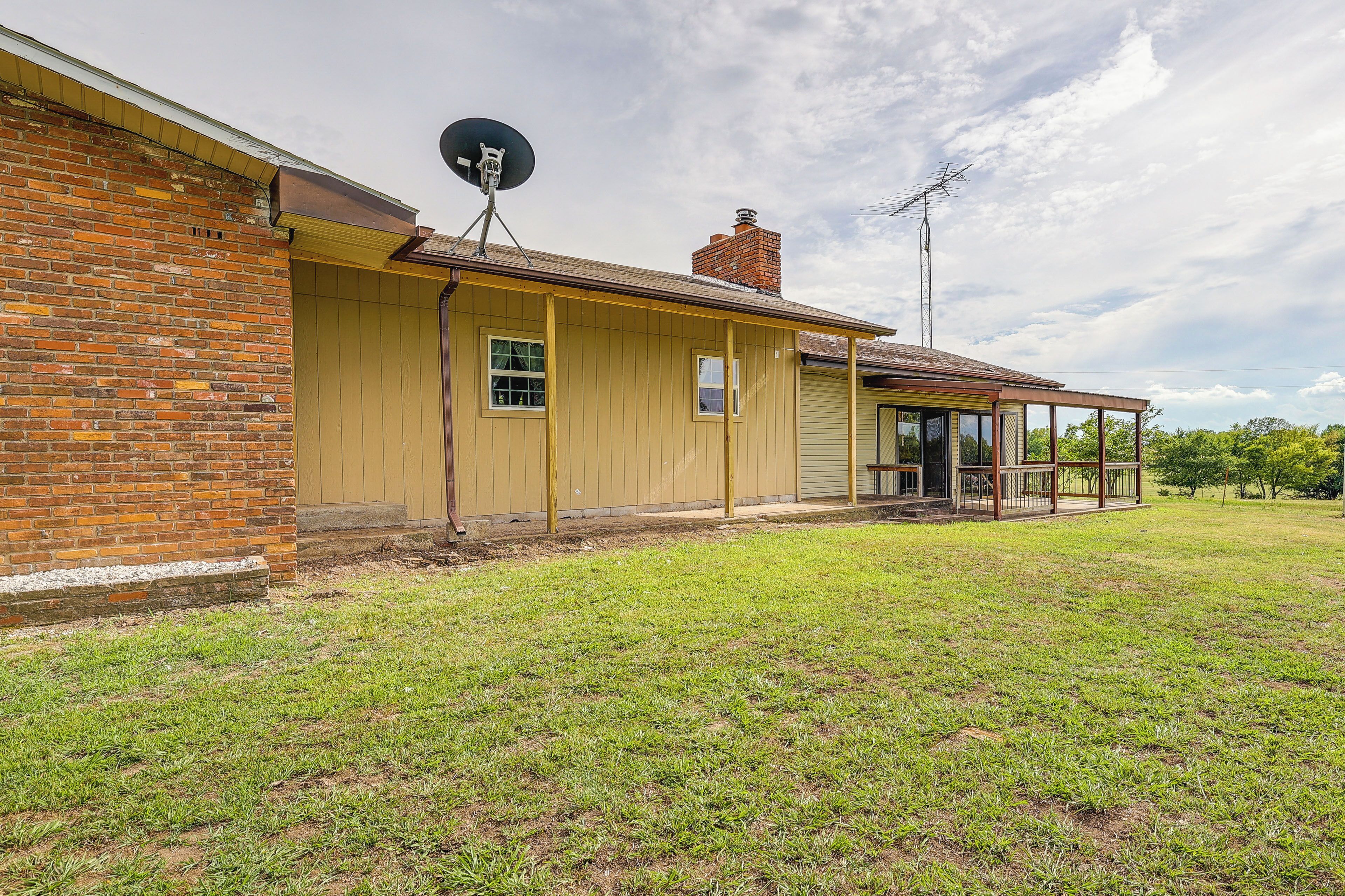 A single-story house with a brick exterior, a satellite dish, and a chimney.