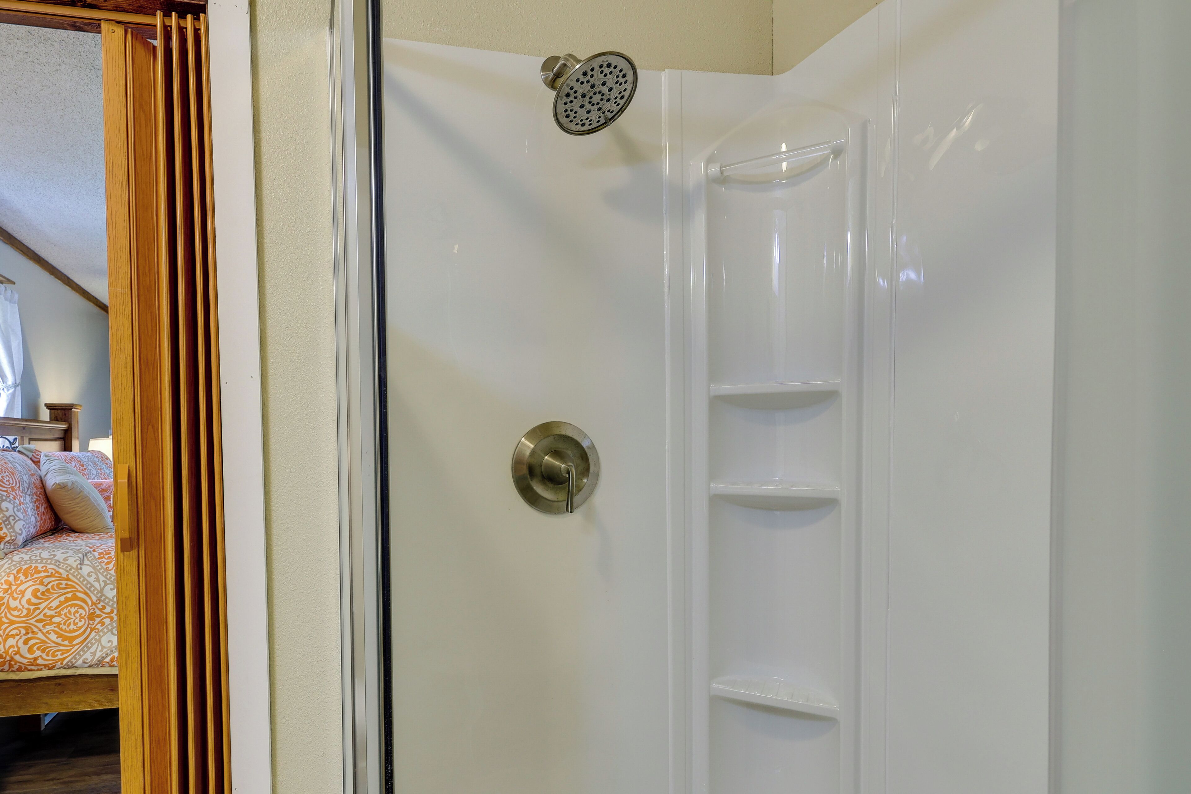 A shower with a glass door and a showerhead.