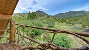 A wooden deck with a view of a green landscape and hills.