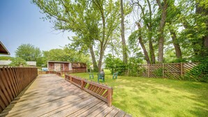 A wooden deck leading to a grassy backyard with a small shed and two chairs. - Group-friendly Lake Erie Getaway w/ Private Yard (Conneaut)