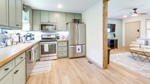 A kitchen with light green cabinets, stainless steel appliances, and a wooden countertop. - Pet-friendly Alabama Retreat w/ Deck & Patio! (Moody)