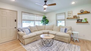 A living room with a beige sectional sofa, a round coffee table, a ceiling fan, and a small side table. - Pet-friendly Alabama Retreat w/ Deck & Patio! (Moody)