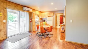 A spacious kitchen with wooden cabinets, a dining table with chairs, and an air conditioning unit. - Murphysboro Retreat w/ Deck Near Kinkaid Lake! (Murphysboro)