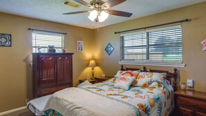 A bedroom with a bed, a nightstand, a dresser, a ceiling fan, and two windows with blinds. - Pet-friendly Cartwright Home w/ Private Backyard! (Cartwright)