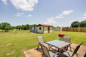 A backyard with a patio table and chairs, a small shed, and a wooden fence. - Pet-friendly Cartwright Home w/ Private Backyard! (Cartwright)