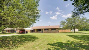 A two-story house with a brick exterior, a covered porch, and a well-maintained lawn. - Pet-friendly Cartwright Home w/ Private Backyard! (Cartwright)