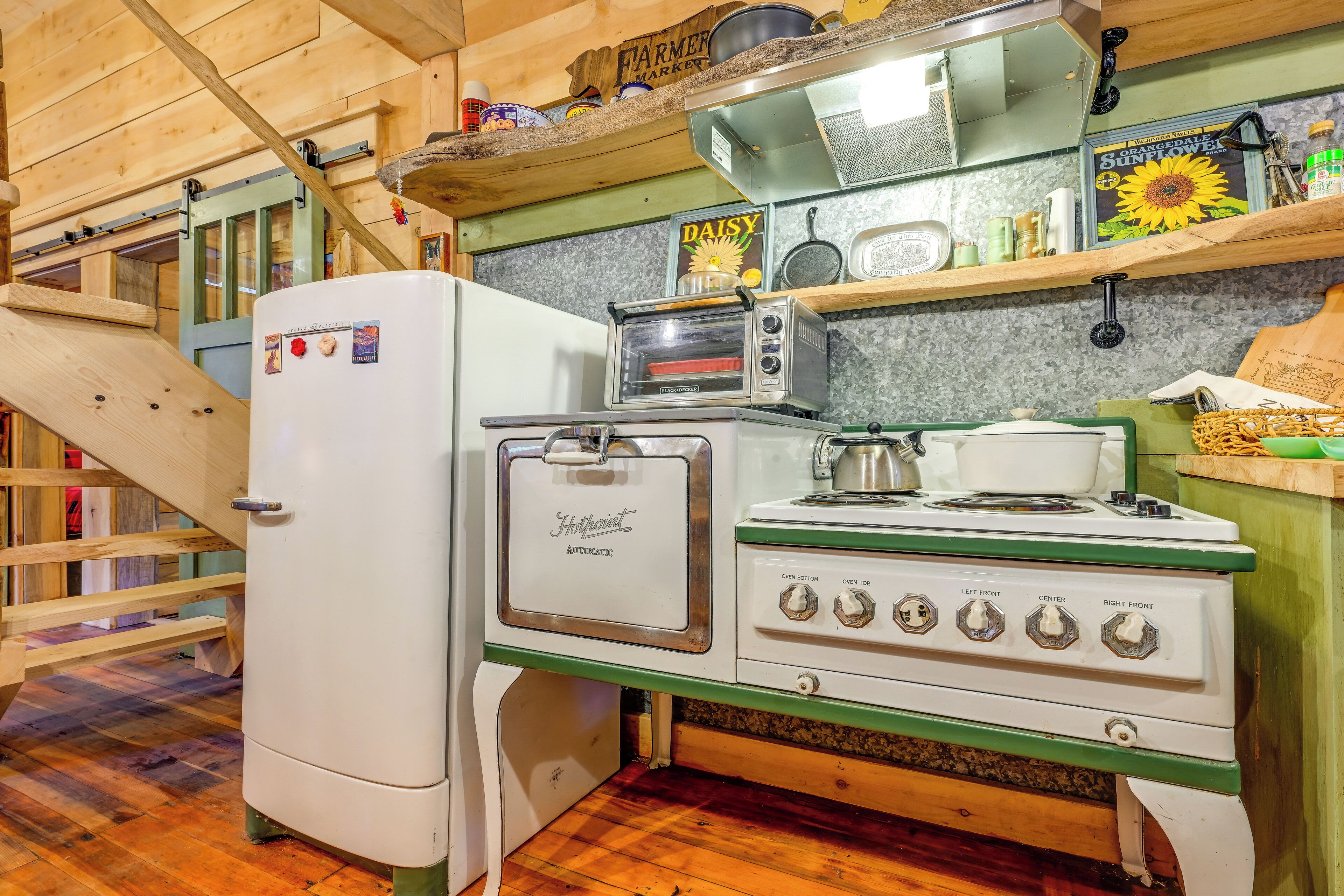 A kitchen with a refrigerator, a stove, a microwave, and a toaster.