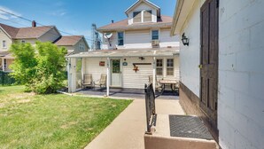 A two-story house with a covered patio and a garage. - Cozy Iowa Getaway w/ Patio & Fenced-in Yard! (Dyersville)