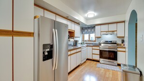 A modern kitchen with a stainless steel refrigerator, built-in oven, and a dishwasher. - Walk to Beach: Charming Maryland Home w/ Yard! (St. Leonard)