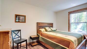 A bedroom with a wooden bed, a nightstand, a chair, and a dresser.
