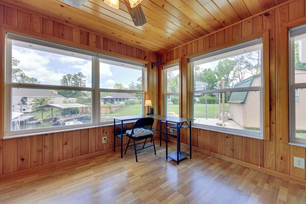 Una habitación con paneles de madera y ventanas amplias que dan a un barrio residencial.