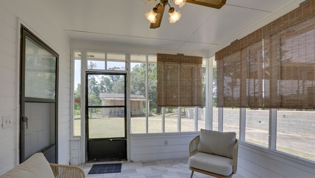 A sunroom with a sofa, chair, and large windows with blinds. - Pet-friendly Slocomb Vacation Rental w/ Sunroom! (Slocomb)