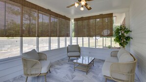 A sunroom with wicker furniture, large windows, and a ceiling fan. - Pet-friendly Slocomb Vacation Rental w/ Sunroom! (Slocomb)